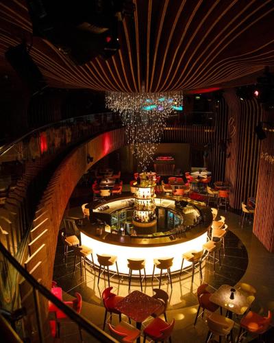 a restaurant with a round bar with tables and chairs at La Cigale Hotel Managed by Accor in Doha