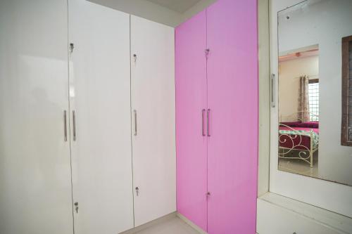 a room with pink and white cabinets and a mirror at Badhram Homestay 4bhk in Alleppey