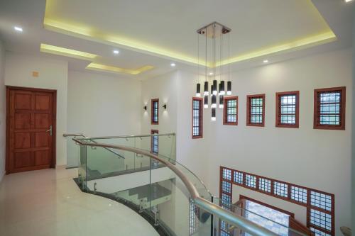 a staircase in a building with a chandelier at Badhram Homestay 4bhk in Alleppey