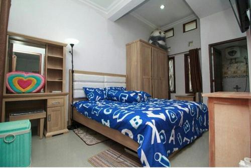 a bedroom with a bed and a dresser and a desk at Stylish House Near Pakuwon Mall in Kejayan