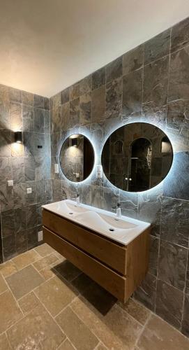 a bathroom with a sink and two mirrors at Castelia in Lumio