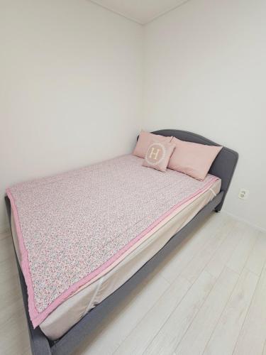 a bed with a pink blanket on top of it at New 패밀리 & 친구 여행 모임 청결하고 쾌적한 넓은 신축아파트 주차 편리 쓰리룸 in Bucheon