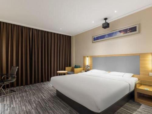a large white bed in a hotel room at City Comfort Inn Beihai RT-Mart High Speed Railway Station in Beihai
