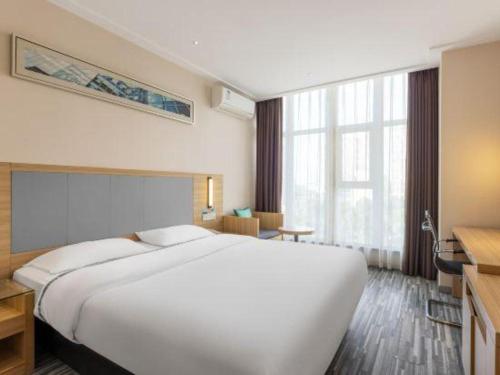a large white bed in a hotel room at City Comfort Inn Beihai RT-Mart High Speed Railway Station in Beihai