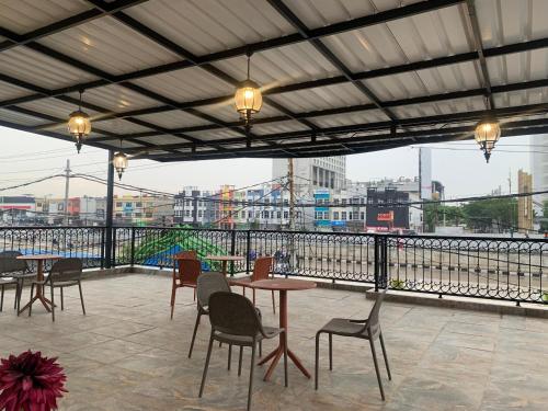 a patio with tables and chairs and a view of a city at The Tasqya Syariah in Sultan Syarif Kasim II International Airport
