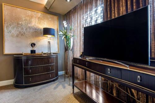 a living room with a large flat screen tv at Curtiss Hotel, an Ascend Collection Hotel in Buffalo