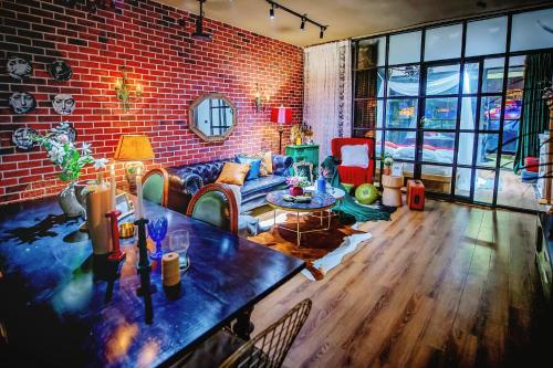 a living room with a couch and a brick wall at Baihong Riverview Apartment-Hongya Cave in Chongqing