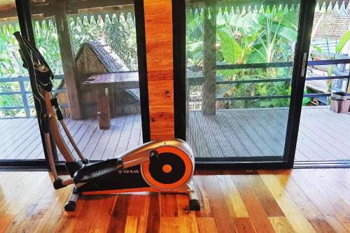 a exercise machine on a wooden floor in a room at Dai House in Xishuangbanna Village in Menghan