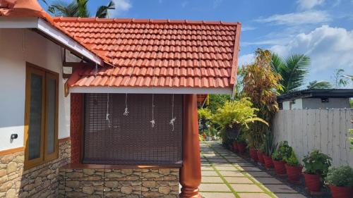 a house with a red roof and a fence at Bell Farms and Resorts in Munroe Island