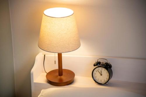 a lamp on a table next to an alarm clock at Scent of Asia in Yokohama