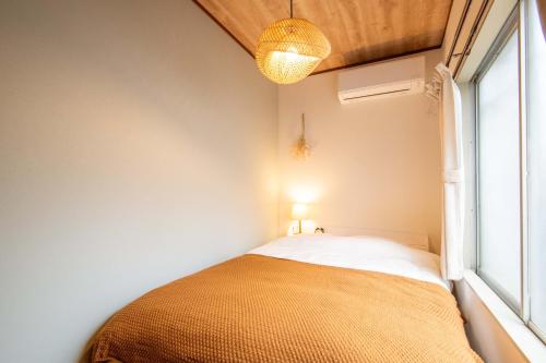 a small bedroom with a bed and a window at Scent of Asia in Yokohama