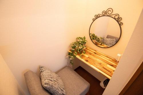 a mirror on a wall next to a bench with a mirror at Scent of Asia in Yokohama