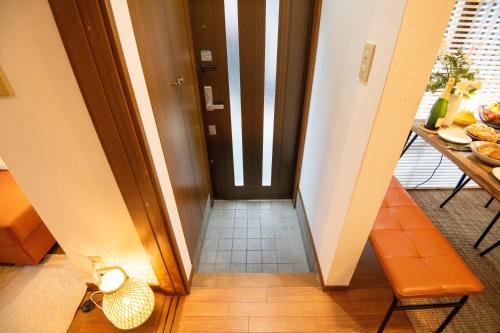 a hallway with a door leading to a room with a table at Scent of Asia in Yokohama