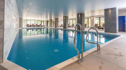 a large swimming pool with blue water in a building at St. Pierre Park Hotel & Golf in St. Peter Port