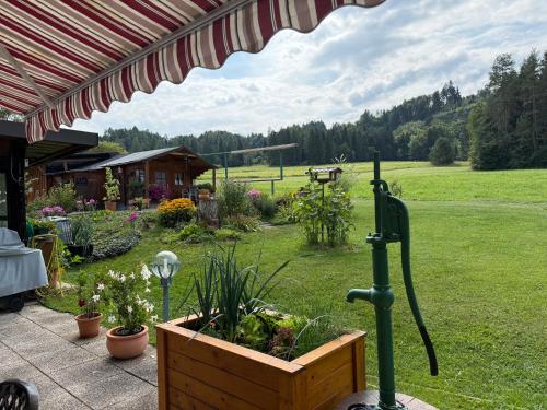 a garden with a wooden planter and an umbrella at Apartment in St. Jakob im Rosental in Sankt Jakob im Rosental