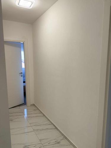 an empty room with a white wall and a door at Bella LUX in Modriča