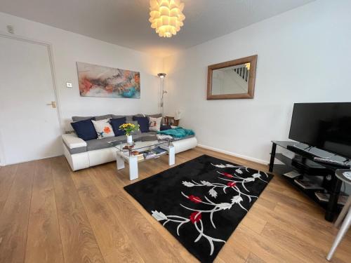 a living room with a couch and a table at Riverside 2 Bedroom Townhouse with Car Charger in Abergavenny