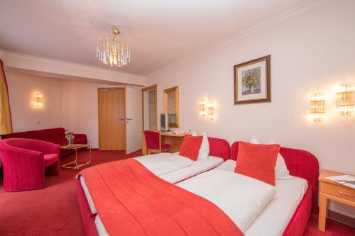 a hotel room with a bed and a red blanket at Berger's Sporthotel in Saalbach Hinterglemm
