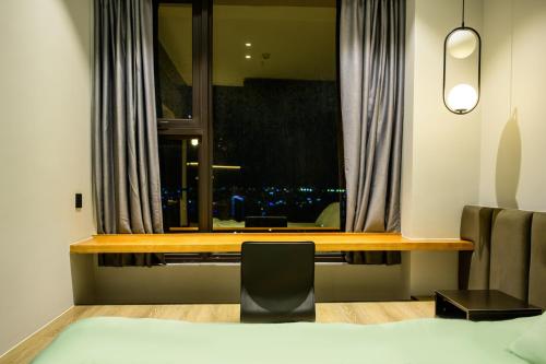 a bedroom with a window with a view of a city at Central Phnom Penh Sky Suite in Phnom Penh