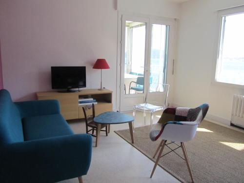a living room with a blue couch and chairs at Appartement Le Cap in Toulon