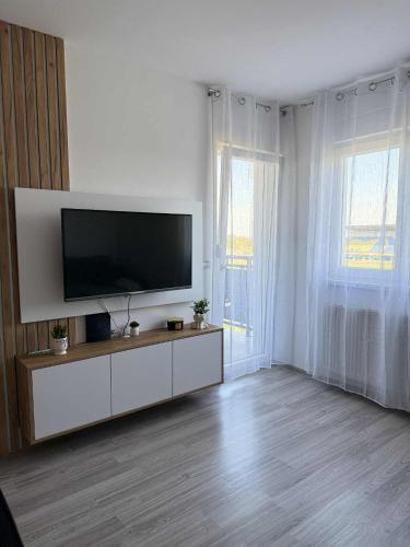 a white living room with a flat screen tv at Bella LUX in Modriča