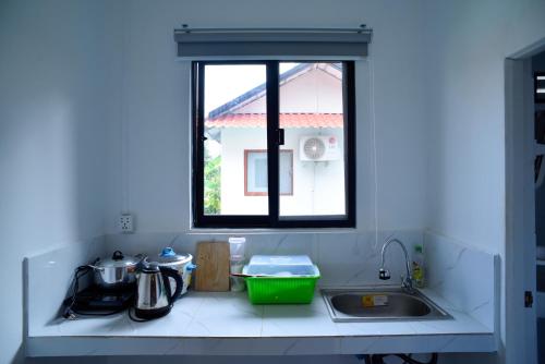 Una encimera de cocina con un fregadero y una ventana. en Densy Khmer Homestay, en Siem Reap