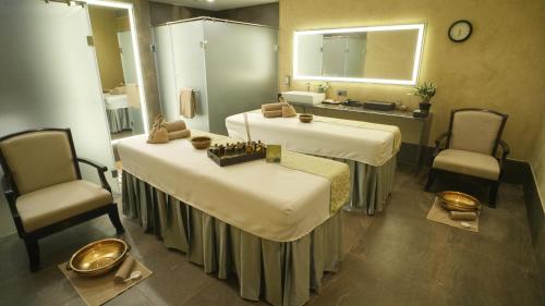 a hotel room with two beds and two chairs at Gift City Club, a member of Radisson Individuals in Gandhinagar