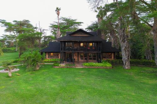 a house with a black roof on a green yard at Kibo Villa Amboseli in Amboseli