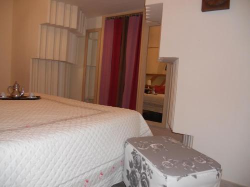 a bedroom with a bed and a stool next to it at Sweet Sweet Home in Tolve