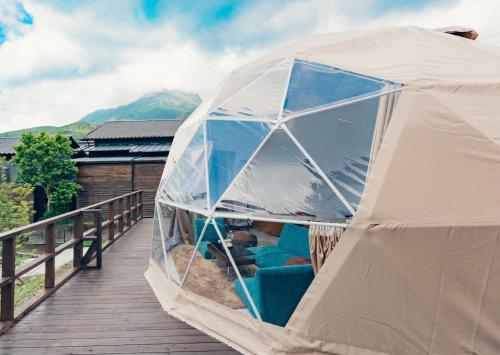 a tent on a deck with a couch in it at The Village Yufuin Onsen Glamping - Vacation STAY 17996v in Yufuin