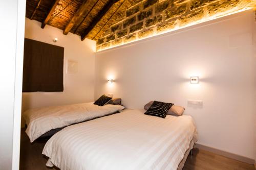 two beds in a room with white walls at Casa San Pascual in Denia