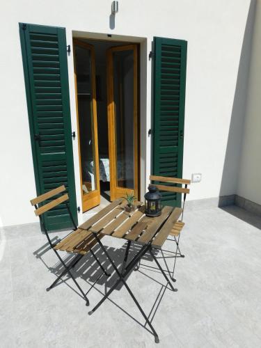 a table and chairs in front of a building with green shutters at Andirivieni Bellagio Guest House in Bellagio