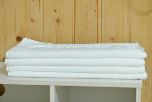 a stack of white towels sitting on a table at Sorak Hostel in Sokcho