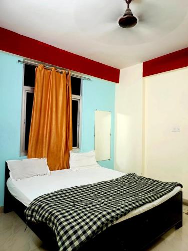 a bedroom with a bed with a checkered blanket at Hotel The Shivay Varanasi Near Kashi Vishwanath Temple in Varanasi