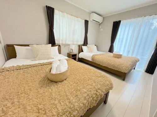 a bedroom with two beds and a large window at Grande Ortho Okinawa Villa Onna 3 - Vacation STAY 83615 in Onna