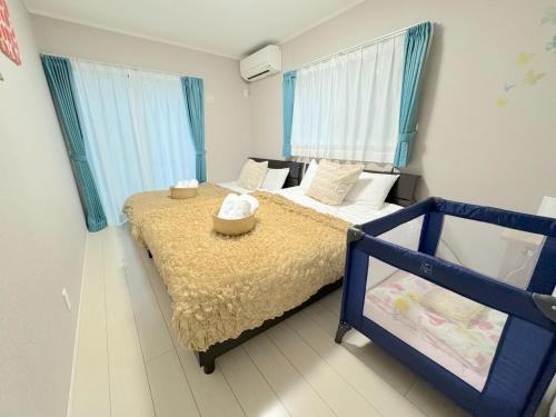 1 Schlafzimmer mit 2 Betten und blauen Vorhängen in der Unterkunft Grande Ortho Okinawa Villa Onna 3 - Vacation STAY 91374 in Meta