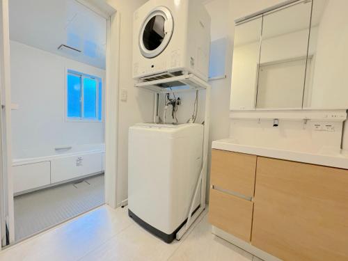 eine Küche mit einem weißen Kühlschrank und einer Mikrowelle in der Unterkunft Grande Ortho Okinawa Villa Onna 3 - Vacation STAY 91374 in Meta