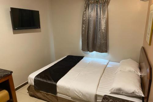 a bedroom with a bed and a television on the wall at Hotel Bliss Near UTM Skudai 5 Mins Only in Skudai