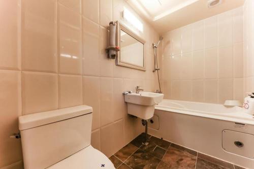 a bathroom with a toilet and a sink and a bath tub at Cinema Motel in Daejeon