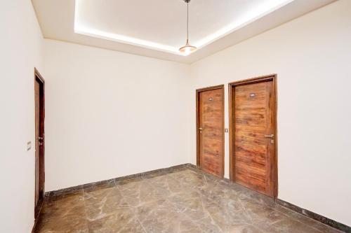 a room with two wooden doors and a tile floor at Super Collection O Sector 108 Noida in Noida
