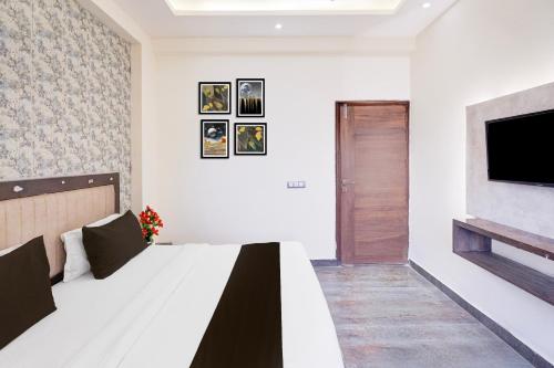 a bedroom with a bed and a tv on a wall at Super Collection O Sector 108 Noida in Noida