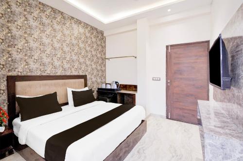 a bedroom with a large bed and a television at Super Collection O Sector 108 Noida in Noida