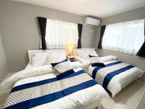 a bedroom with two beds with blue and white sheets at Grande Ortho Okinawa Villa Onna 3 - Vacation STAY 83617 in Onna