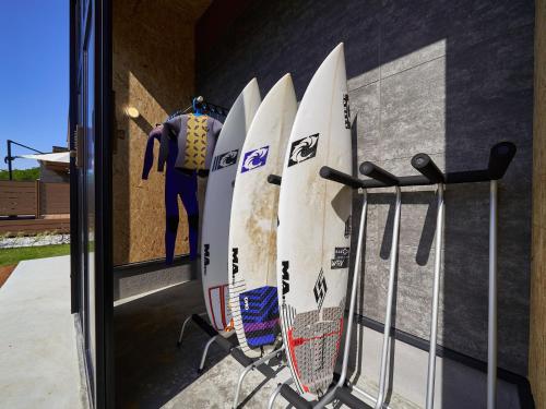 a row of surfboards hanging on a wall at Rakuten STAY HOUSE Kujukuri Ichinomiya 102 3LDK with BBQ terrace in Ichinomiya