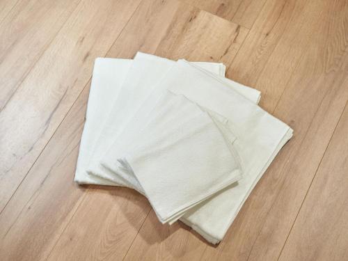 a pile of white towels on a wooden floor at Rakuten STAY HOUSE Kujukuri Ichinomiya 102 3LDK with BBQ terrace in Ichinomiya