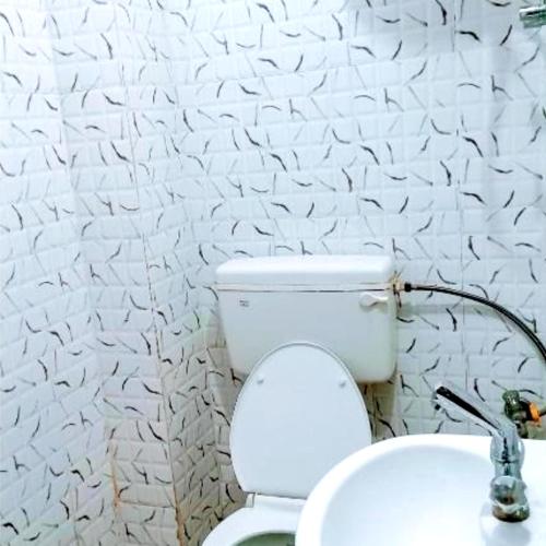 a bathroom with a toilet with a hose at Hotel The Shivay Varanasi Near Kashi Vishwanath Temple in Varanasi