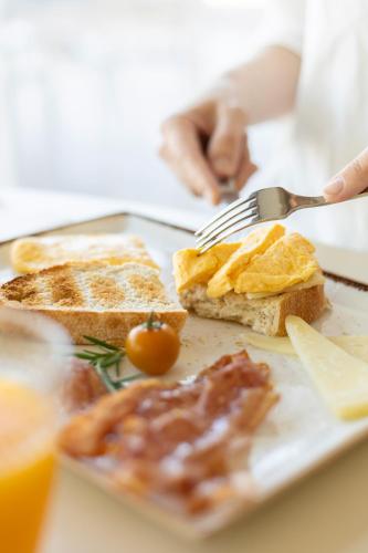 a plate of breakfast food with toast and a fork at Hotel Noguera Mar in Denia