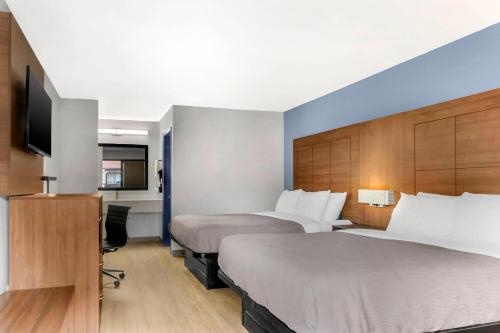 a hotel room with two beds and a desk at Quality Inn Madison - Huntsville in Madison