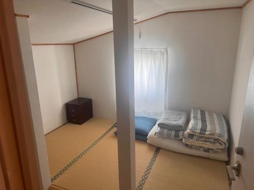 a small room with a bed and a window at Otaro Village - Vacation STAY 96435v in Otaru