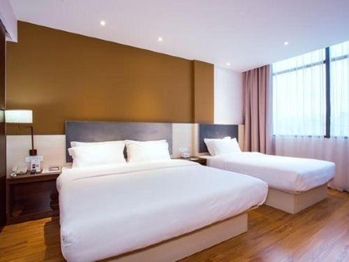 a hotel room with two beds and a large window at JTOUR Inn Guilin Two Rivers and Four Lakes Walmart in Guilin